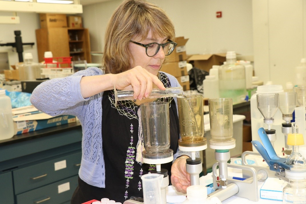 female scientist pouring water into small container