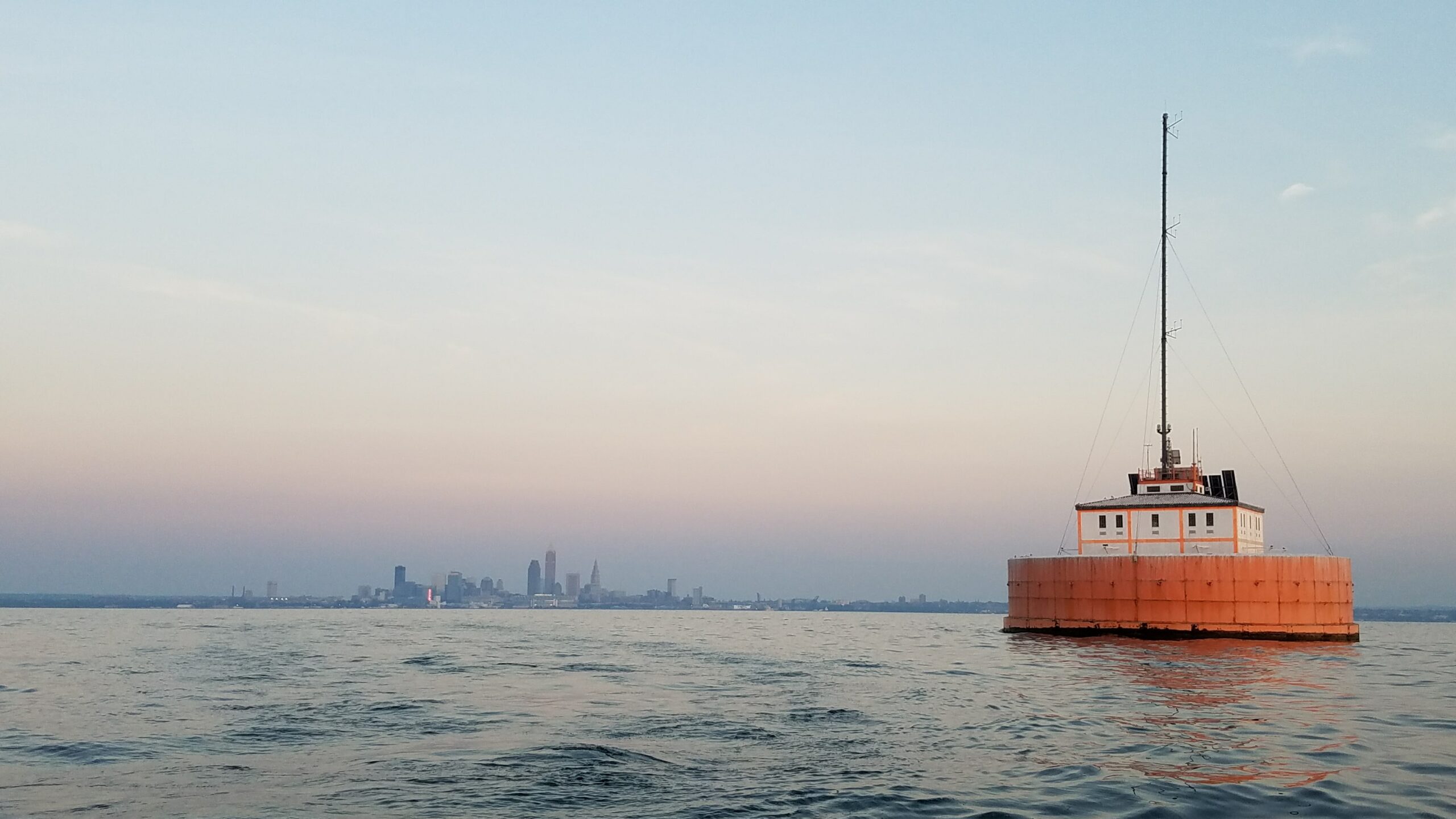 photo of building in water with skyline of city in backgroun